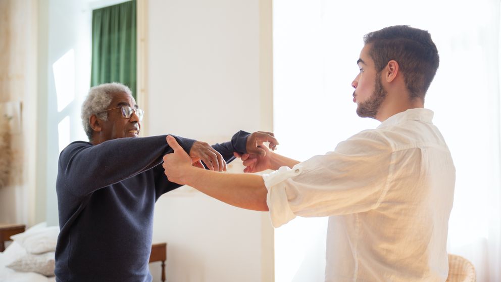 An Elderly Man Talking to the Man in White Shirt while Holding Hands